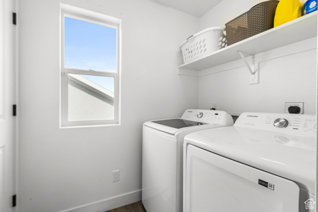 Laundry room featuring washer and clothes dryer and dark wood finished floors