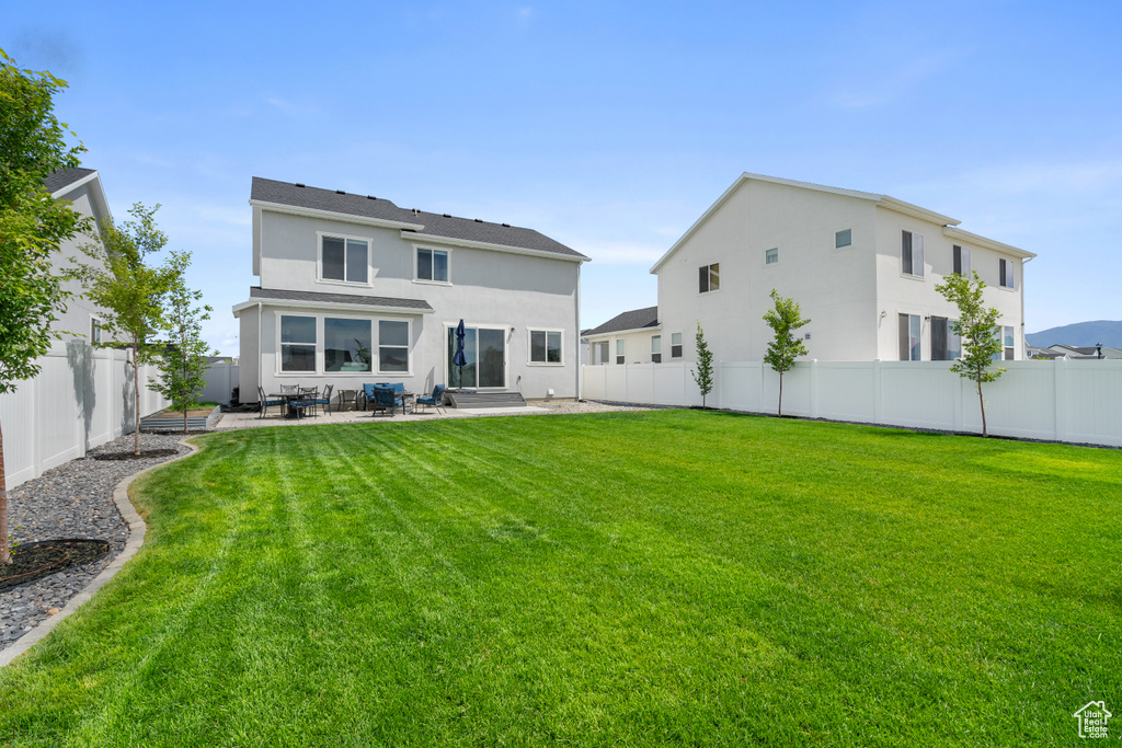 Rear view of property with a patio, stucco siding, and a fenced backyard