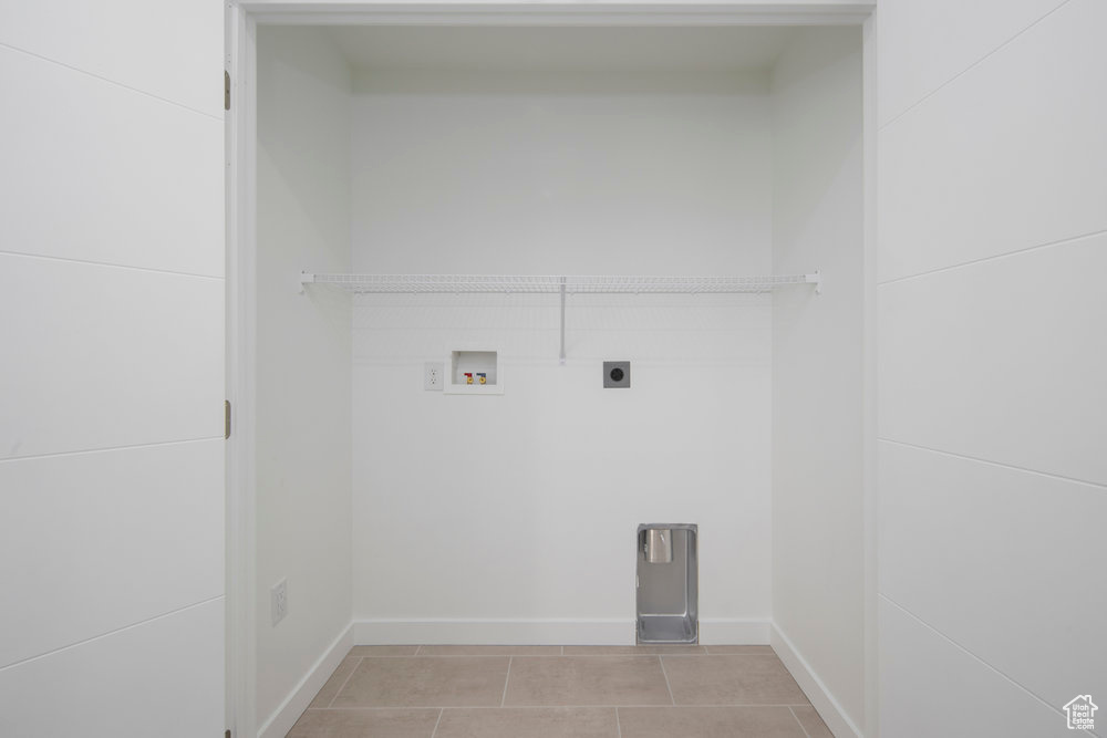Laundry room with electric dryer hookup, light tile patterned floors, and washer hookup