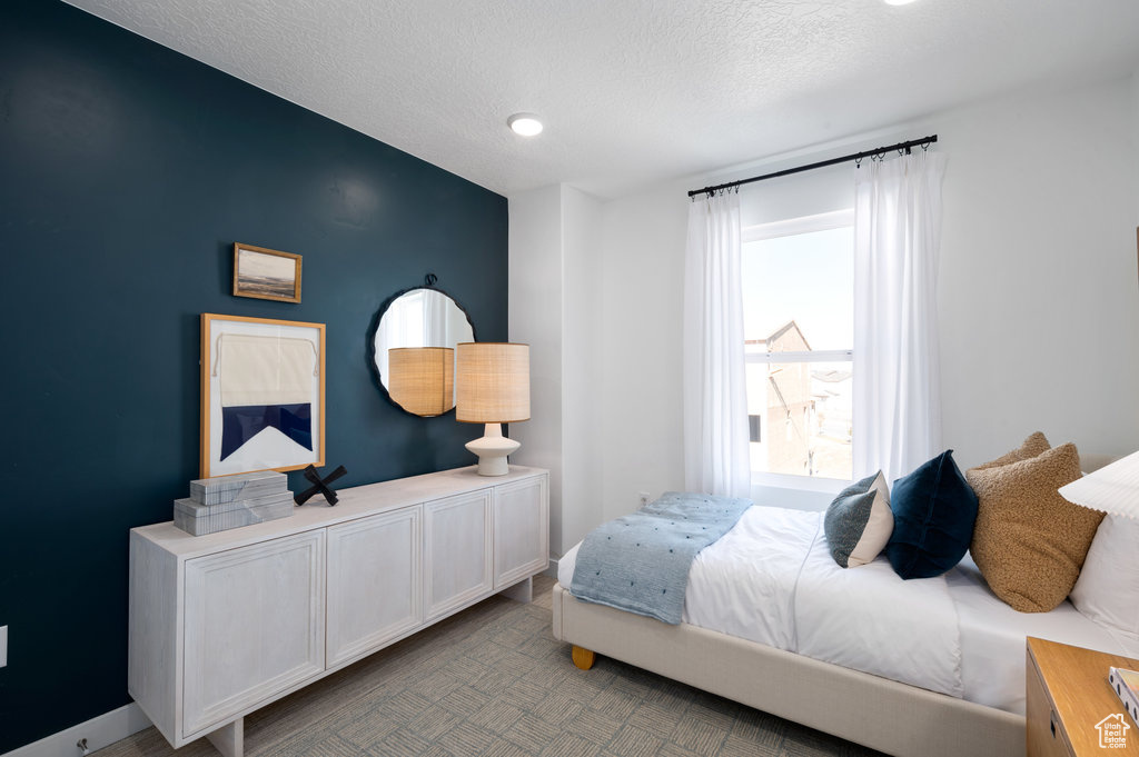 Bedroom with a textured ceiling and baseboards