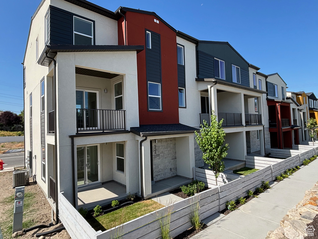 View of front facade featuring stucco siding, a balcony, and a residential view