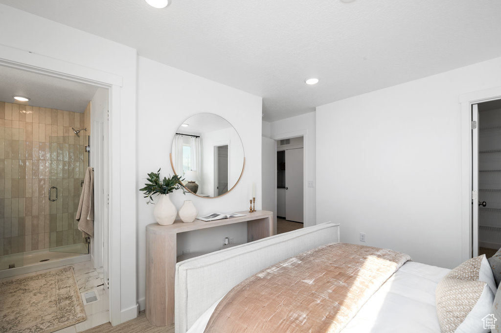 Bedroom featuring recessed lighting, ensuite bath, and a walk in closet