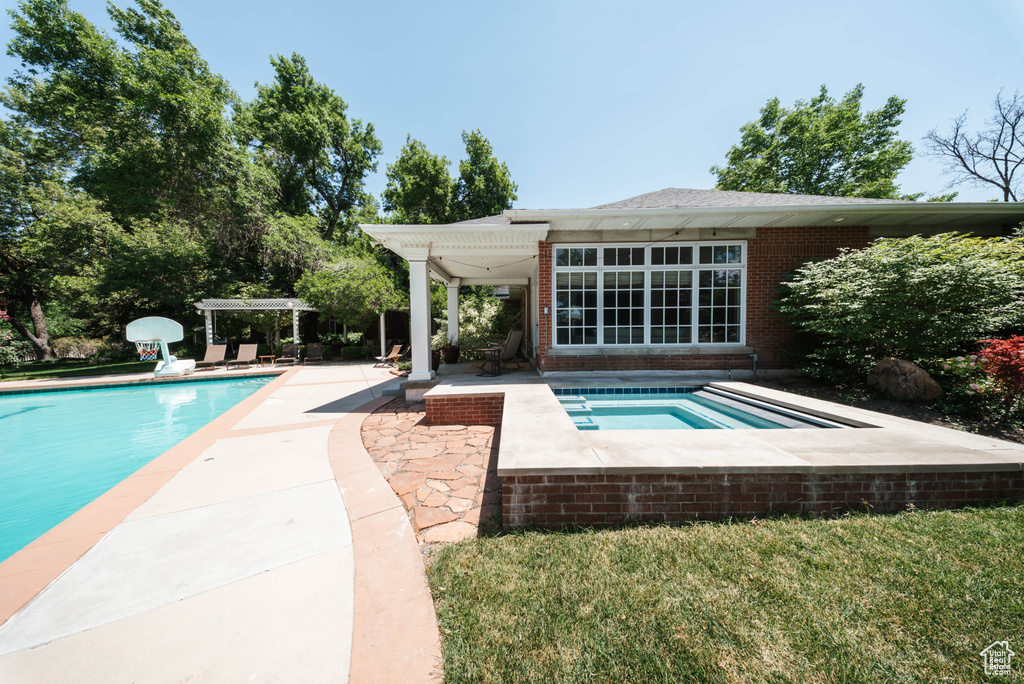 Swimming pool featuring an in-ground hot tub and a patio