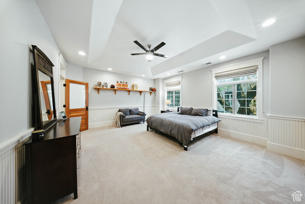 Bedroom featuring light colored carpet, wainscoting, recessed lighting, a ceiling fan, and a decorative wall