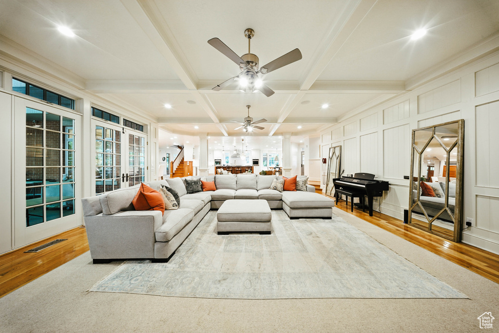 Living area featuring coffered ceiling, wood finished floors, beamed ceiling, ceiling fan, and recessed lighting