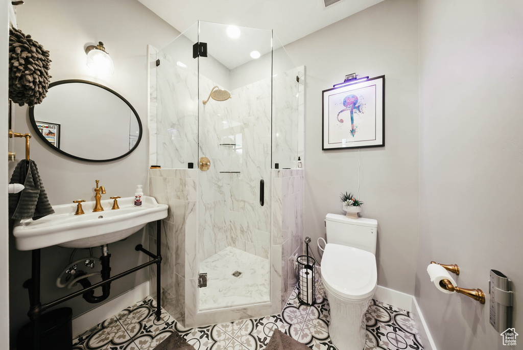 Bathroom featuring a marble finish shower and tile patterned floors