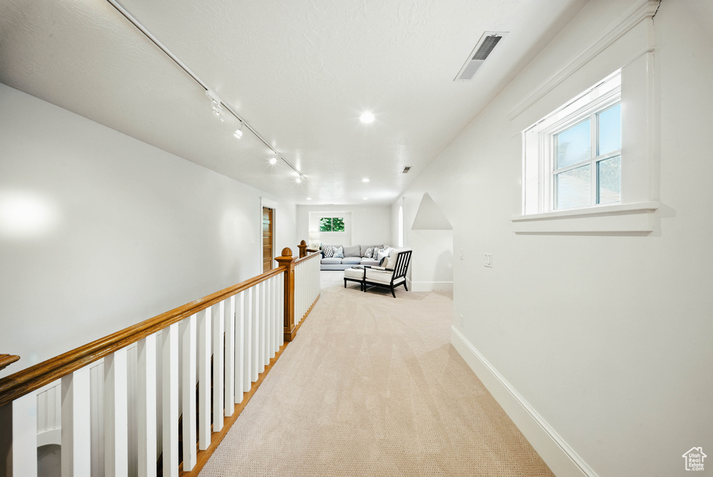 Hall with light carpet and track lighting