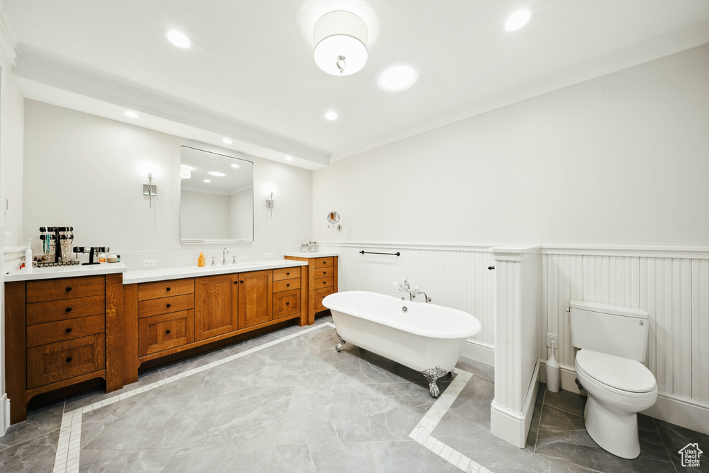Bathroom featuring marble tiled floors, a wainscoted wall, vanity, a soaking tub, and recessed lighting