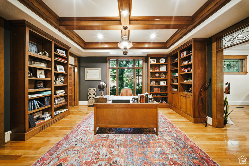 Office area featuring light wood-style flooring, coffered ceiling, beam ceiling, and ornamental molding