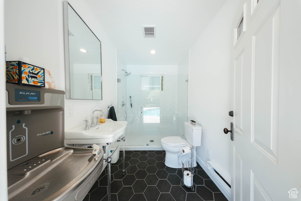 Bathroom featuring a baseboard heating unit, a shower stall, tile patterned flooring, and recessed lighting