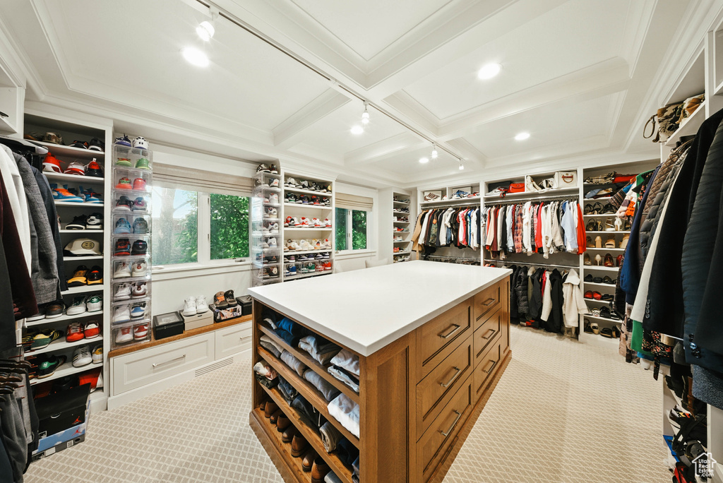 Spacious closet featuring light carpet, coffered ceiling, and beamed ceiling