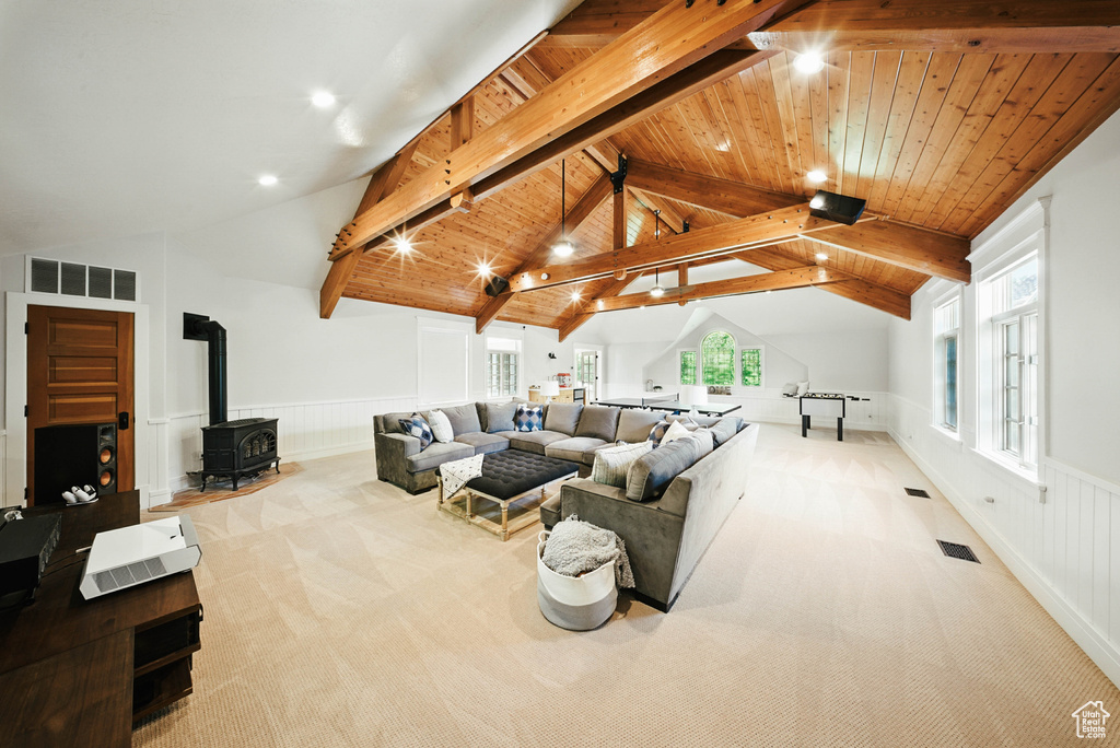 Living room featuring a wood stove, carpet floors, wainscoting, plenty of natural light, and recessed lighting