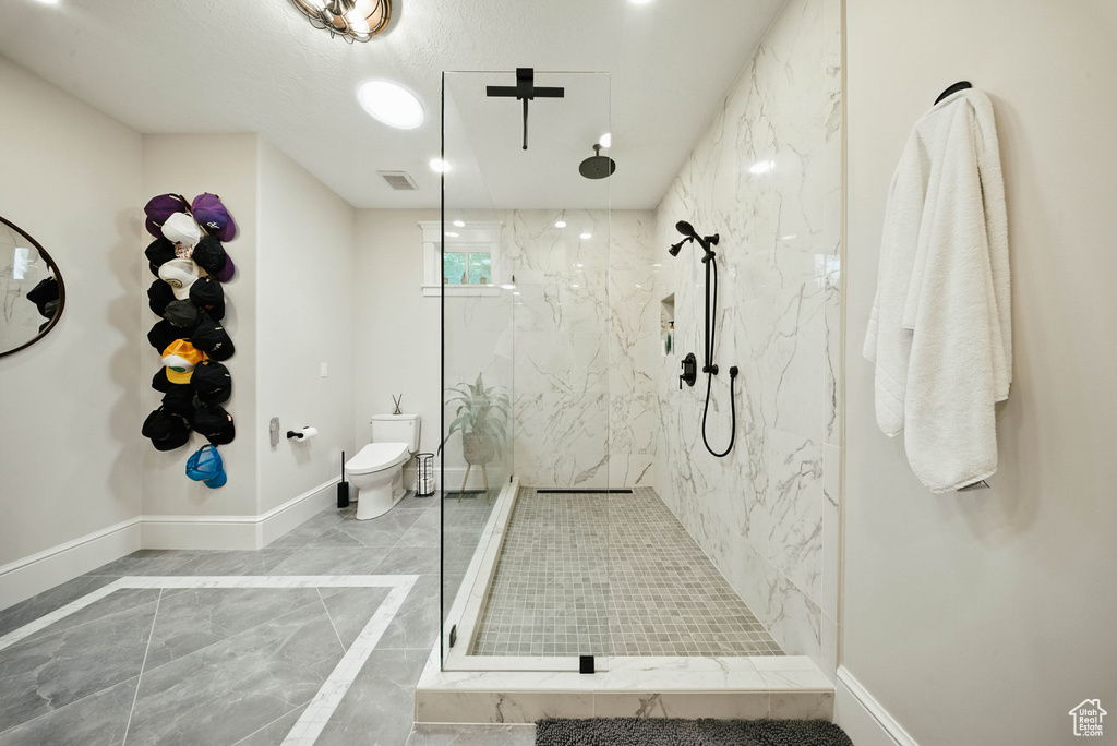 Bathroom featuring marble finish floors and a marble finish shower