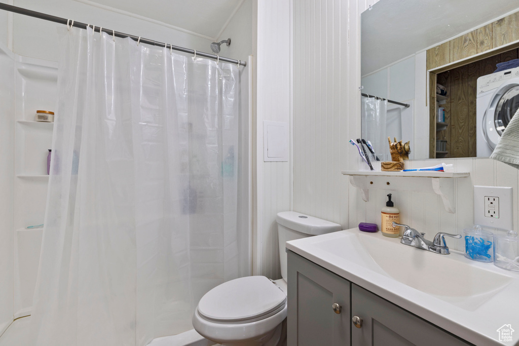 Bathroom featuring washer / dryer, curtained shower, vanity, and crown molding