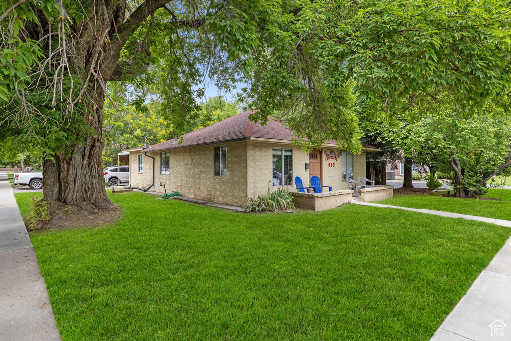 Ranch-style home featuring a front lawn and roof with shingles