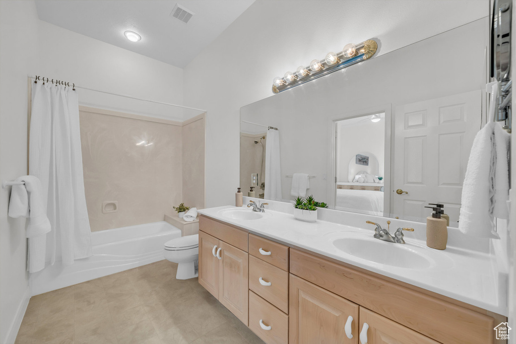 Bathroom featuring double vanity and shower / bathtub combination with curtain