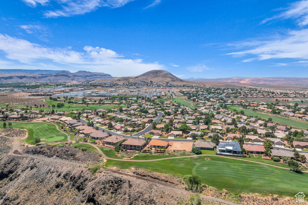 Aerial perspective of suburban area featuring a mountainous background and a golf course