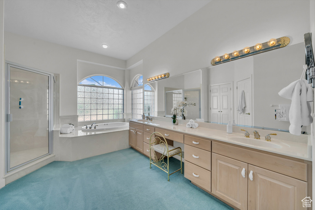 Bathroom with double vanity, a stall shower, a bath, and recessed lighting