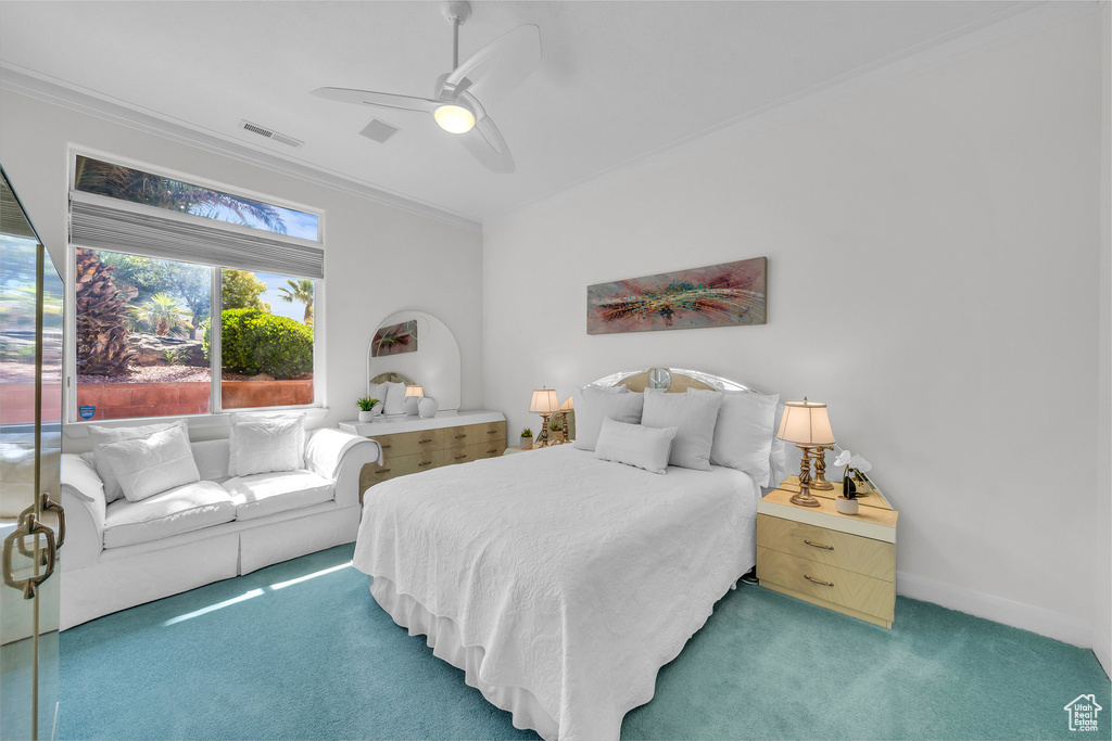 Carpeted bedroom with crown molding and ceiling fan