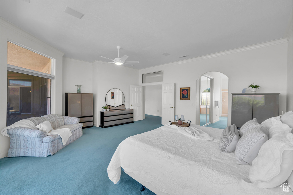 Bedroom with carpet flooring, arched walkways, ornamental molding, and ceiling fan