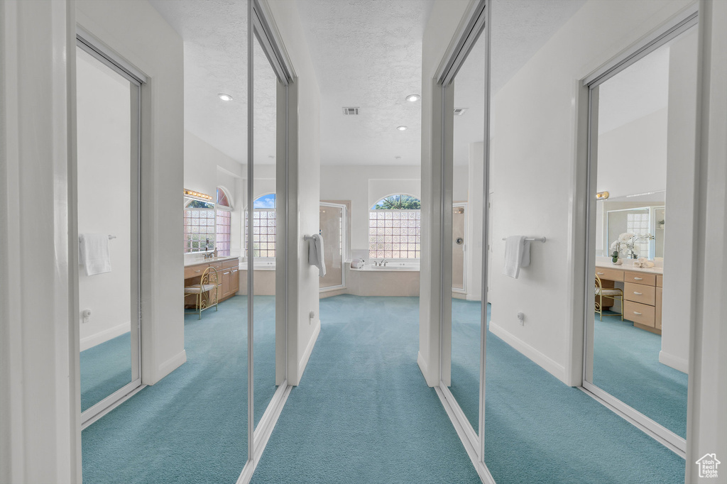 Hall featuring carpet flooring, recessed lighting, and a textured ceiling