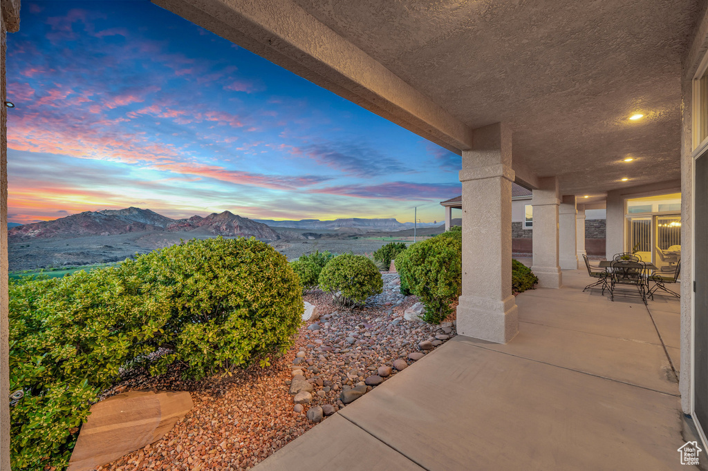 Patio terrace at dusk featuring a mountain view and a patio area