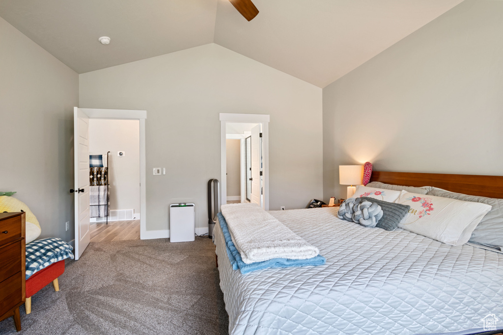 Bedroom with lofted ceiling, dark colored carpet, and a ceiling fan