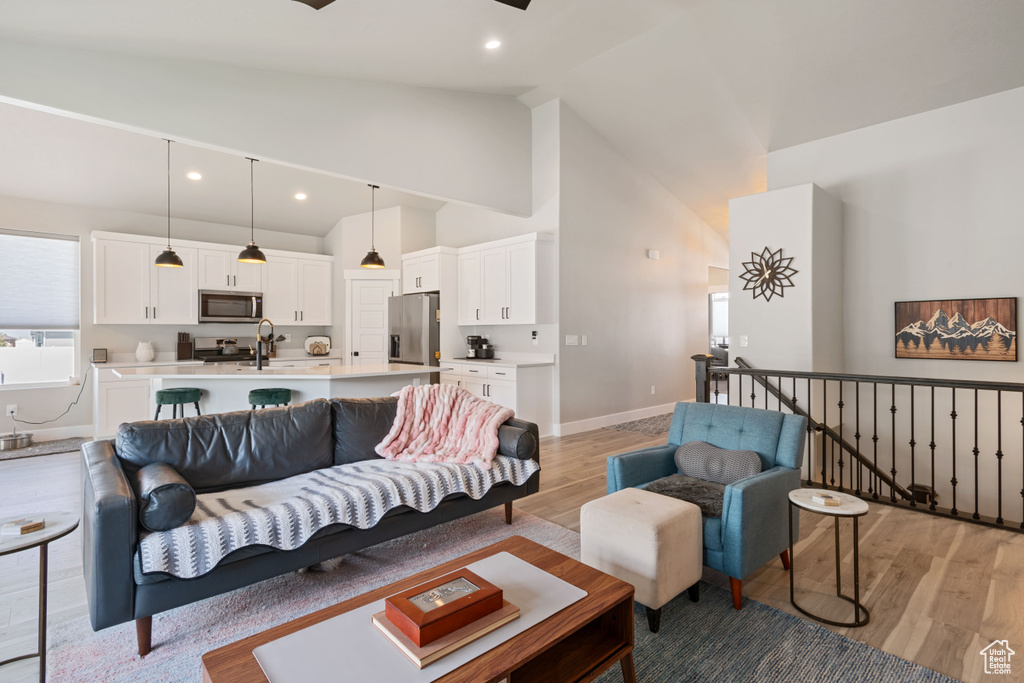 Living room featuring light wood finished floors, recessed lighting, and high vaulted ceiling