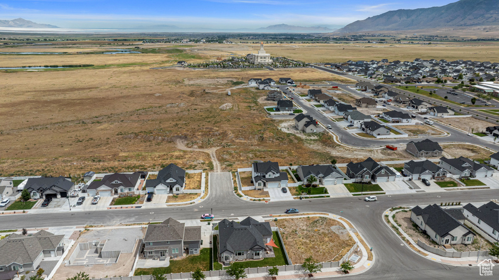 Aerial overview of property\'s location featuring nearby suburban area and a mountainous background