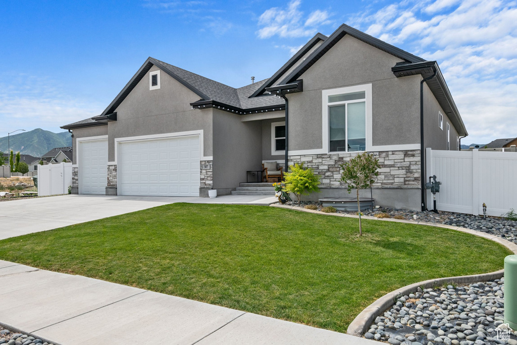 View of front of property featuring stone siding, an attached garage, stucco siding, and concrete driveway