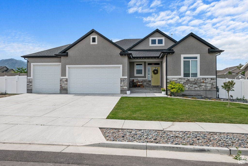 View of front of house featuring stucco siding, stone siding, an attached garage, concrete driveway, and roof with shingles