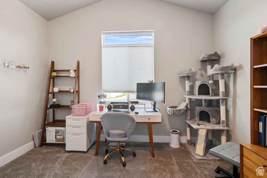 Carpeted home office featuring baseboards and vaulted ceiling