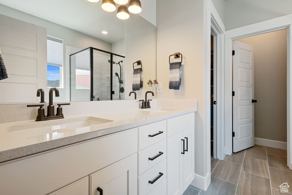 Bathroom featuring a stall shower and double vanity