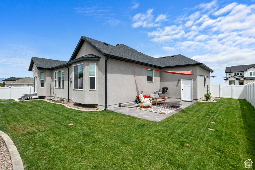 Back of house with a patio area, a fenced backyard, and stucco siding