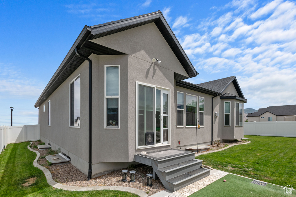 View of home\'s exterior featuring stucco siding and a fenced backyard