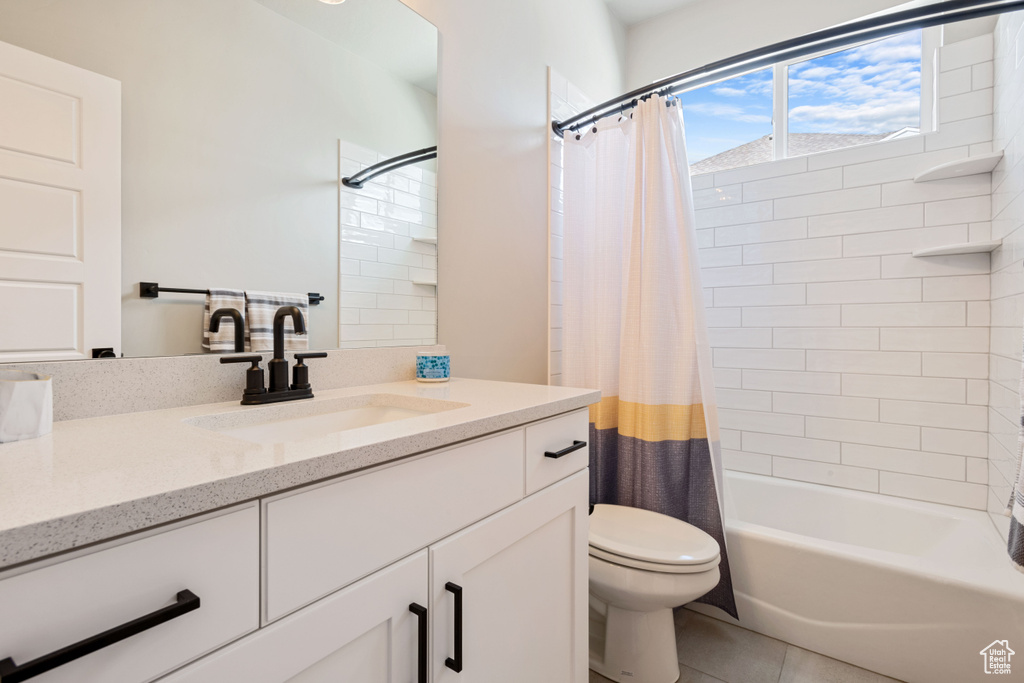 Bathroom featuring vanity, tile patterned floors, and shower / bath combo with shower curtain