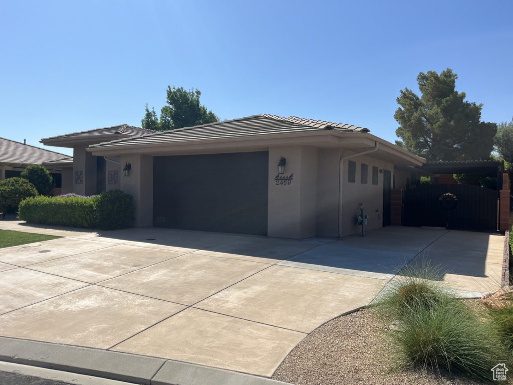View of front of home with driveway, an attached garage, stucco siding, and a tile roof