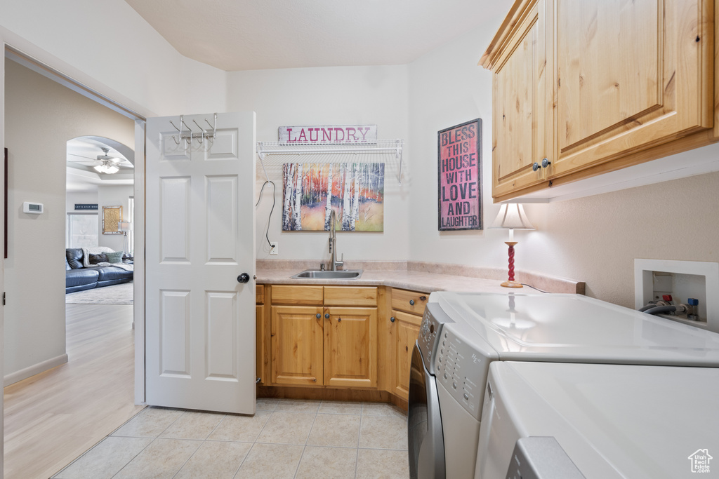 Laundry room featuring cabinet space, separate washer and dryer, ceiling fan, light tile patterned flooring, and bar with sink