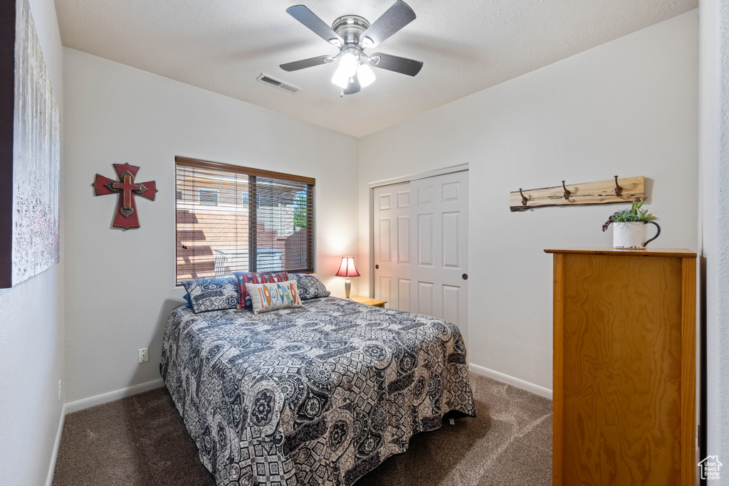 Bedroom with carpet flooring, a ceiling fan, and a closet
