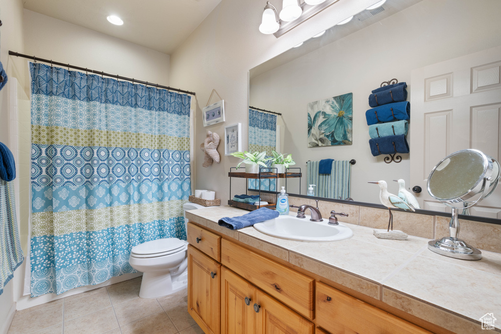 Bathroom featuring tile patterned floors, vanity, and a shower with curtain
