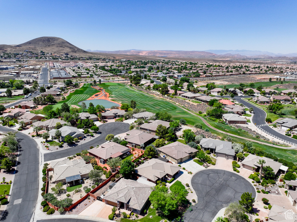 Aerial perspective of suburban area with a golf course and a water and mountain view
