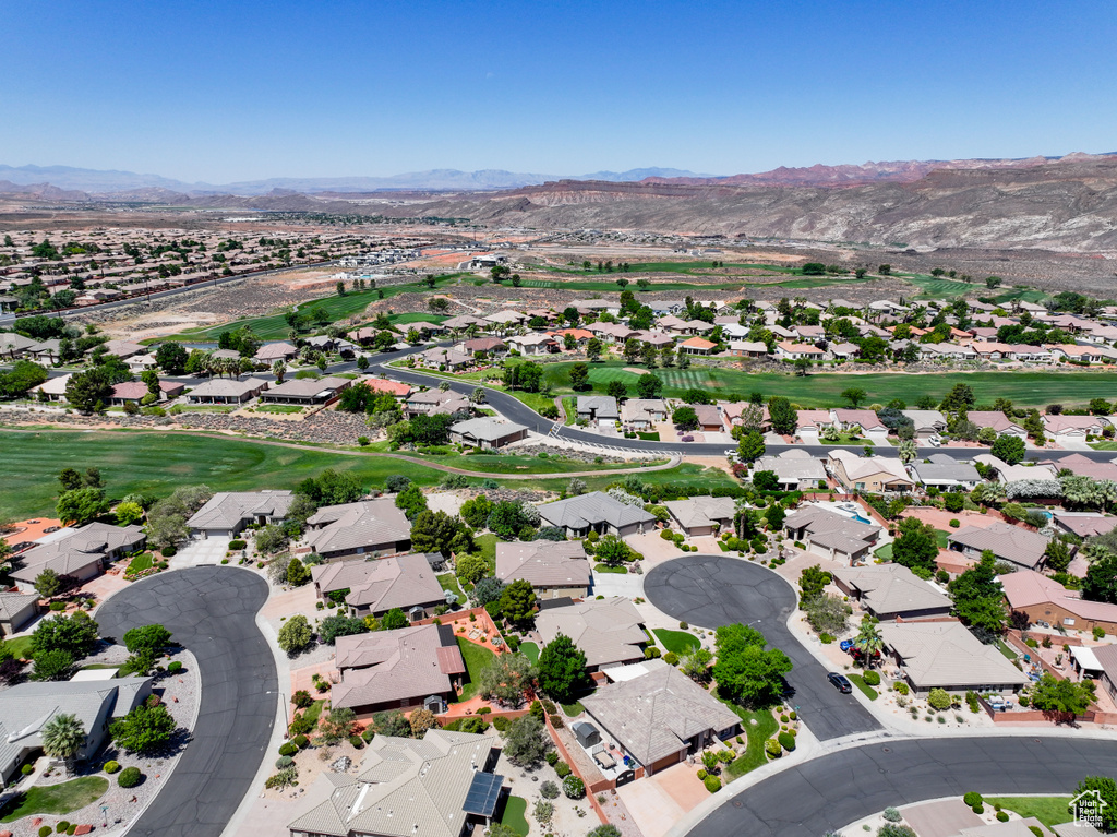 Aerial perspective of suburban area with mountains and a golf club