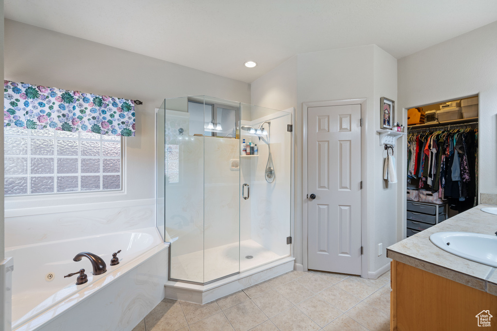 Full bath with a jetted tub, a shower stall, tile patterned floors, and double vanity