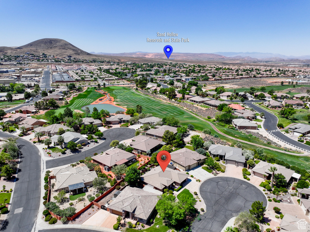 Aerial perspective of suburban area with a mountain backdrop and a golf course