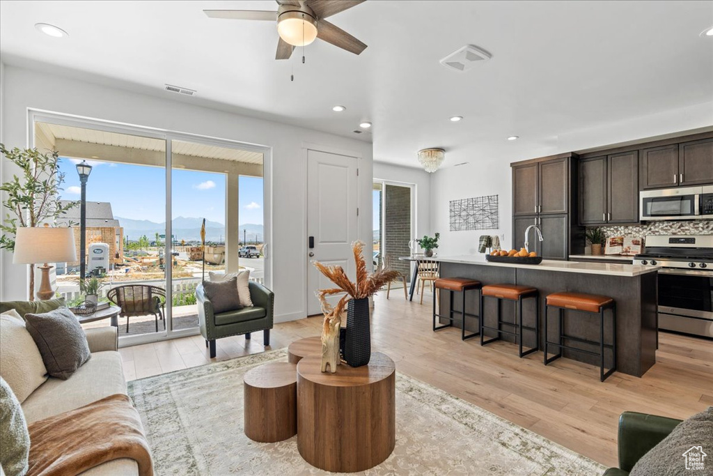 Living area with light wood-style floors, a mountain view, a ceiling fan, and recessed lighting