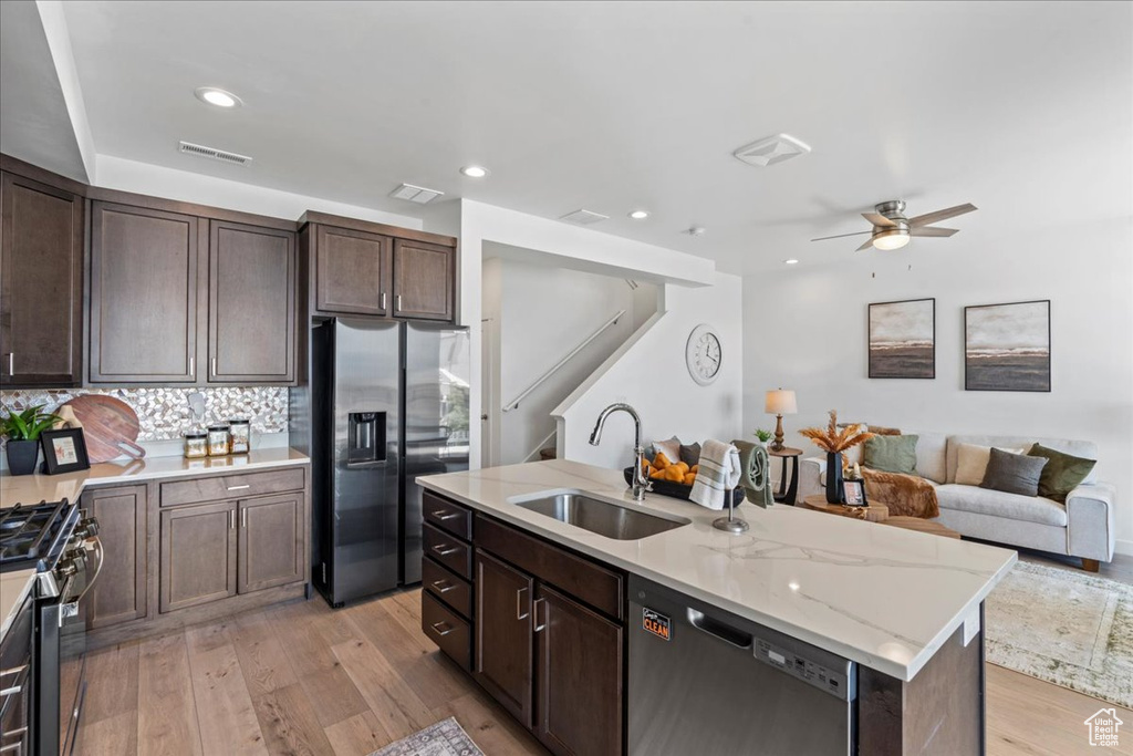 Kitchen with appliances with stainless steel finishes, light wood-type flooring, a ceiling fan, dark brown cabinetry, and recessed lighting
