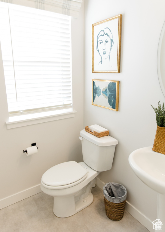Half bath featuring baseboards and toilet
