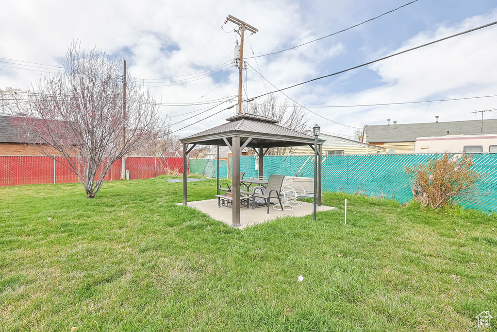 Fenced backyard featuring a gazebo and a patio area