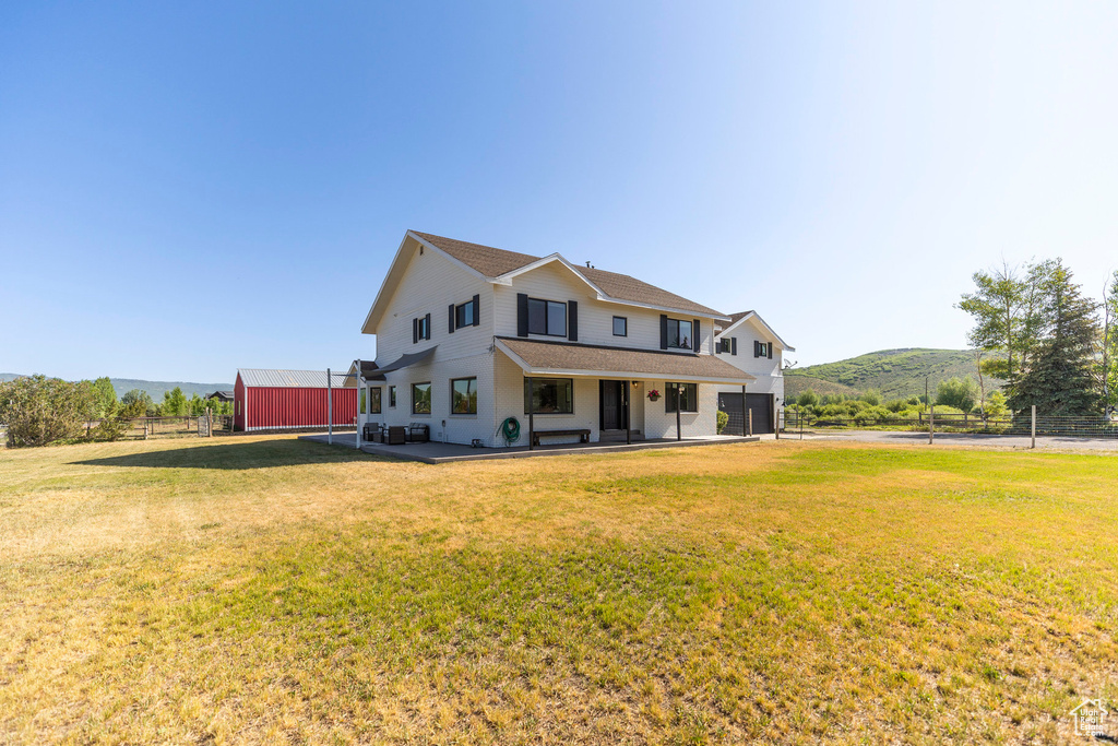 View of front of house with a mountain view, an attached garage, and roof with shingles