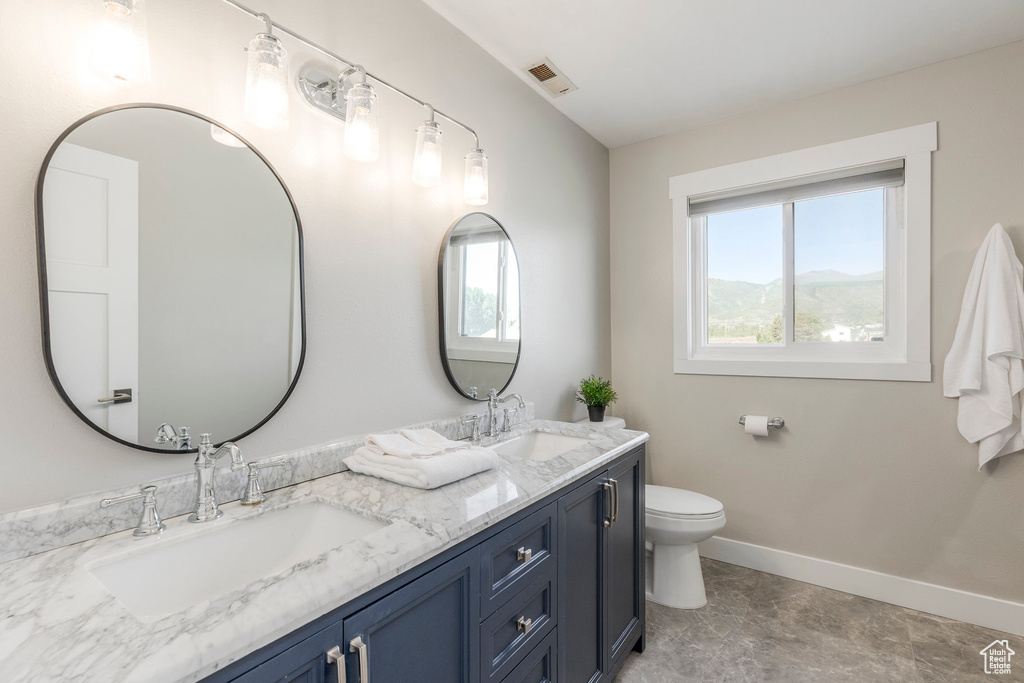 Bathroom with baseboards and double vanity